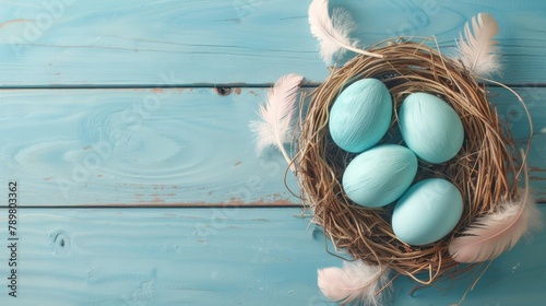 Blue Easter eggs in a nest on a blue wooden background.