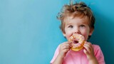 The child eats a donut on a blue background