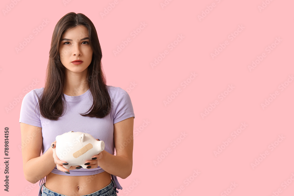 Beautiful young worried woman with broken patched piggy bank on pink background Beautiful young worried woman with broken patched piggy bank on pink background