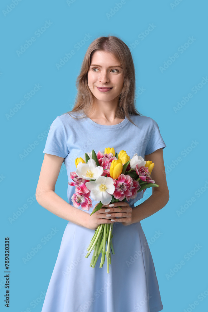 Pretty young woman with bouquet of beautiful tulips on blue background Pretty young woman with bouquet of beautiful tulips on blue background