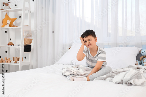 Cute sleepy little boy sitt...