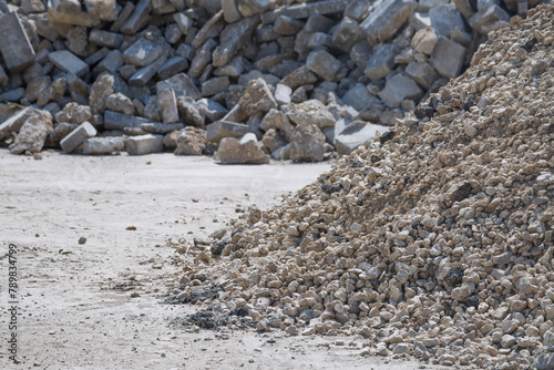 A pile of gravel on the background of a pile of removed old curb stone