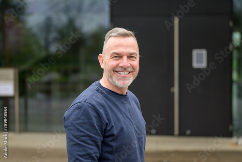 Portrait of a middle aged man looking friendly with a beaming smile to camera