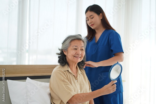 Young Caregiver Tenderly Combing Elderly Woman's Hair