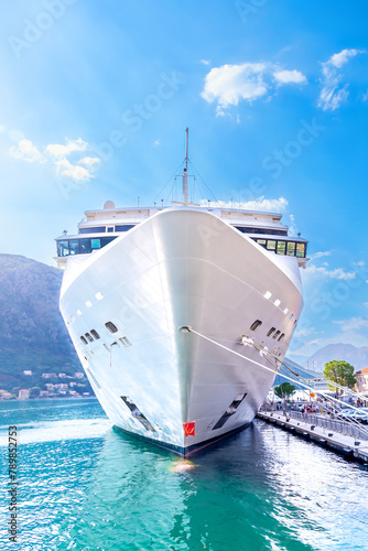 A large beautiful white tourist ship on the pier. Front view