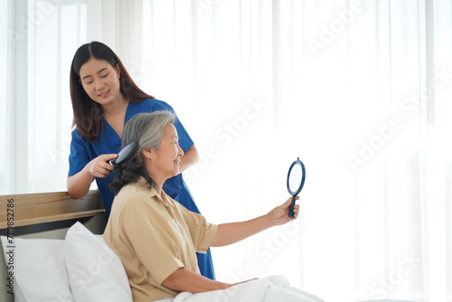 Young Caregiver Tenderly Combing Elderly Woman's Hair