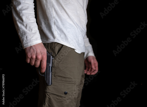 Man holding a gun in his hand on a black background