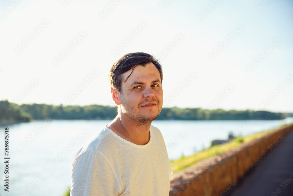 34 years old male on vacation in summer, sunny day on lake or river. Positive emotions, leisure activity, relax. walk along embankment waterfront, promenade 34 years old male on vacation in summer, sunny day on lake or river. Positive emotions, leisure activity, relax. walk along embankment waterfront, promenade