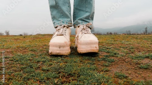 Walking a girl with white shoes on the grass