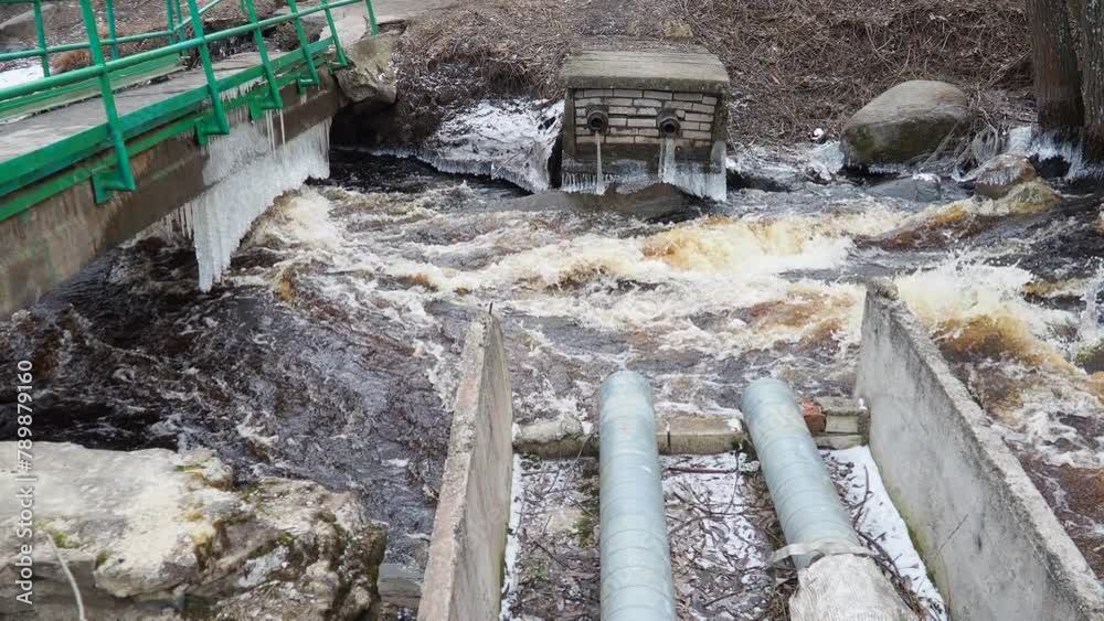 Spring flood. Rushing water in the river. Dark ferrous water rushes in ...