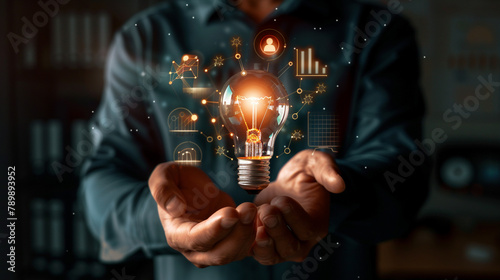 Businessman holding creative light bulb with growth graph, analytics icons. Utilizing analytics technology to develop new strategies and insights that enhance successful performance in global business