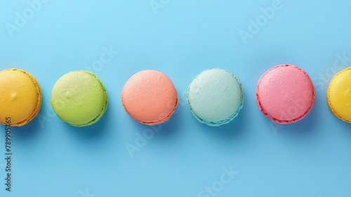 A row of colorful macarons on a blue background