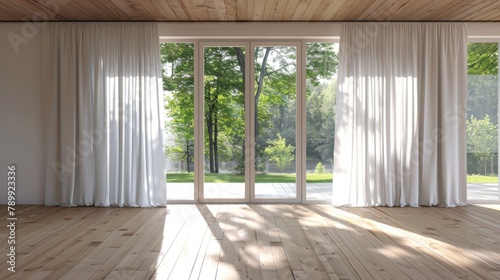 A large open room with white curtains and a view of trees. The room is empty and has a clean, minimalist feel