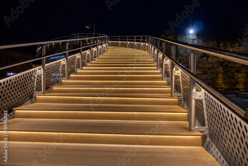 The staircase is illuminated at night. Evening lighting of pedestrian bridges. Lanterns at night. The light of the lanterns illuminates the stairs. Twilight in the city.