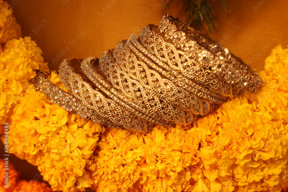 stone studded intricate bangles spread on yellow marigold flowers stone studded intricate bangles spread on yellow marigold flowers
