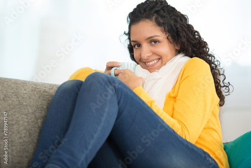 lady sat cosily on the sofa with a hot drink