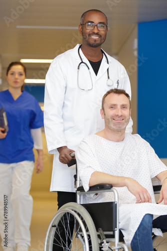 male medical doctor pushing patient on wheelchair