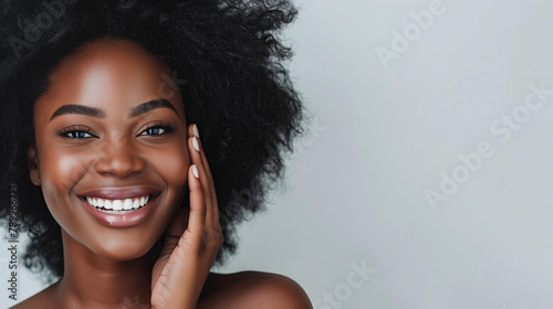 beautiful black woman with radiant skin smiling while touching her face on a white background, beauty and spa advertising banner or poster, copy space,advertising beauty and spa services photo