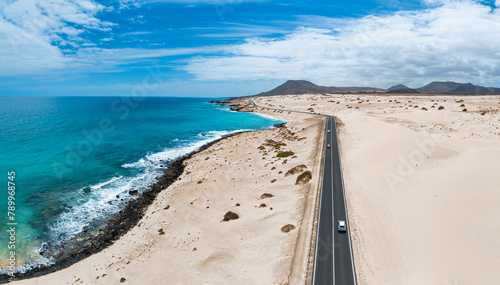 Aerial high level panoramic view of the sand dunes and road between the coast and Parque Natural sand dunes heading to Corralejo Fuerteventura  Canary Islands Spain