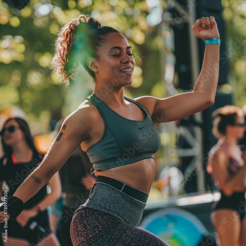 A toned woman in a sports outfit, dancing at an outdoor music event. 