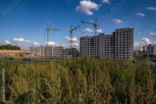 silhoette of tower cranes on construction site, providing housing for low-income citizens of third world countries