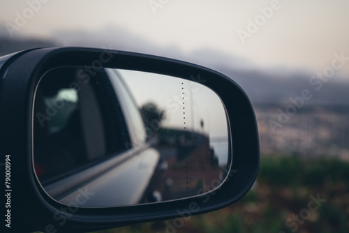 Car side mirror reflecting road during travel