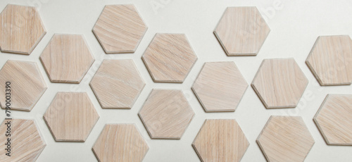 Wooden honeycomb made of light walnut, coated with colored varnish. Hexagon in interior design. Isolated on white background. Laid out with a gap between parts