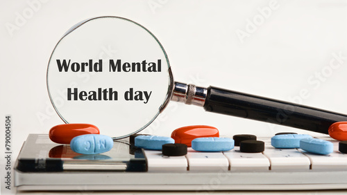 Depression and support concept. World mental health day through a magnifying glass on a light background on a calculator, about scattered pills, vitamins