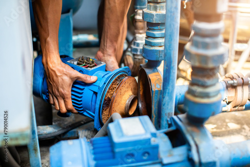 Selective focus to hand of plumber repair and remove motor of centrifugal water pump. Plumbers working to installation centrifugal water pump motor.