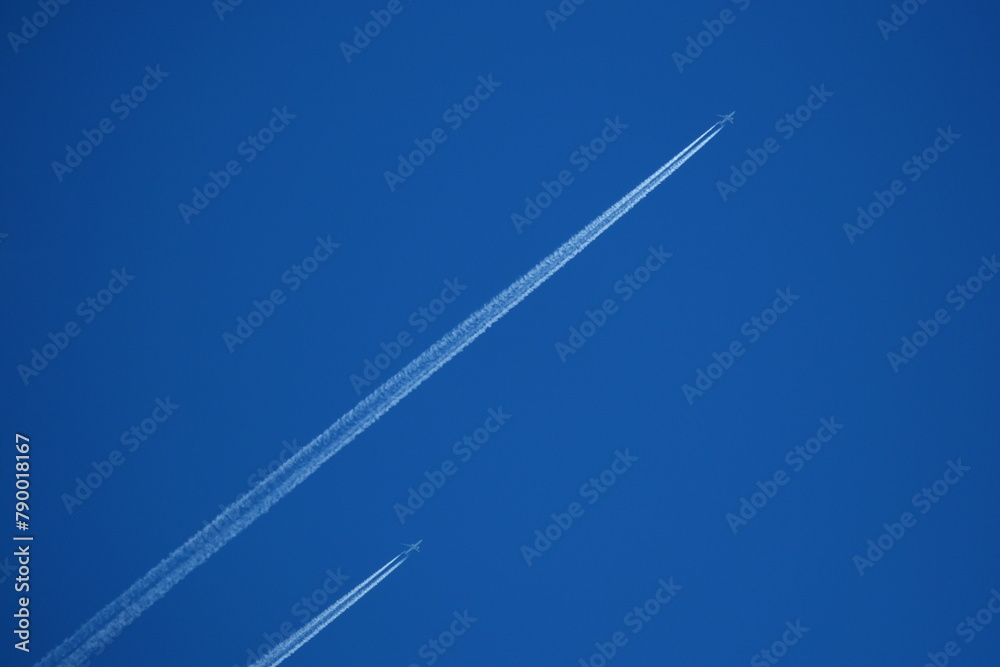 two planes in the sky, two parallel airplane tracks in the blue sky, contrails - obrazy, fototapety, plakaty 