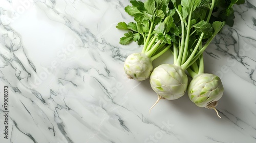 Heads of kohlrabi lie on the surface of white marble photo