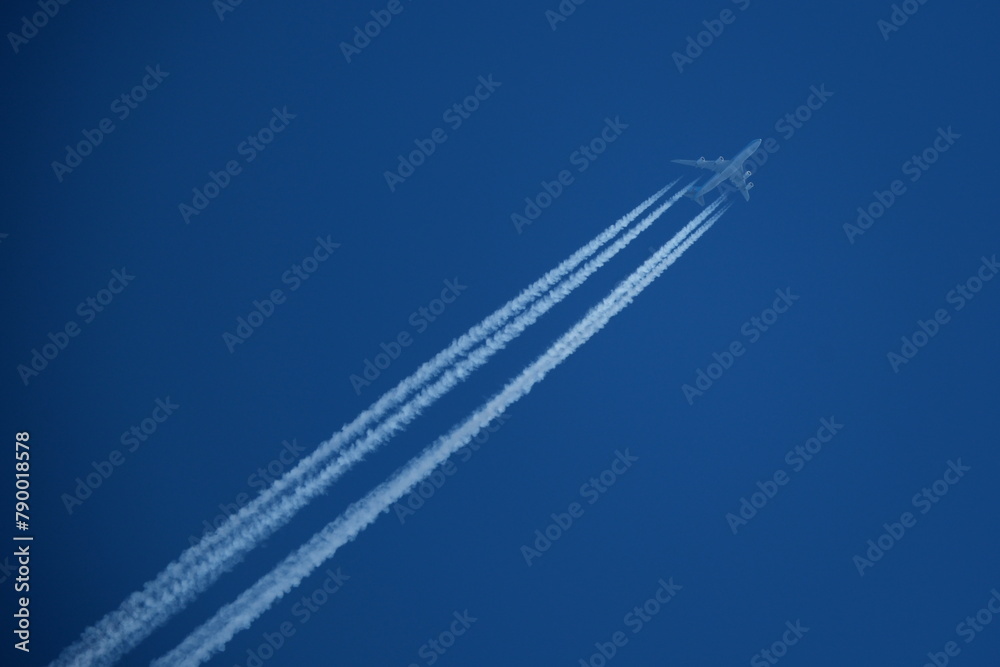Airplane in the blue sky with contrails in the air. Airplane in the blue sky with contrails in the air.