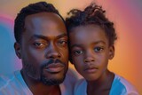 A father and his young daughter pose for a tightly cropped, intimate portrait with warm colors