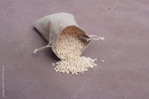 Close up of Organic split polished white urad dal (Vigna mungo) on a ceramic white bowl with the gradient background of urad dal polished. Top view, ماش کی دال ،دال ماش photo