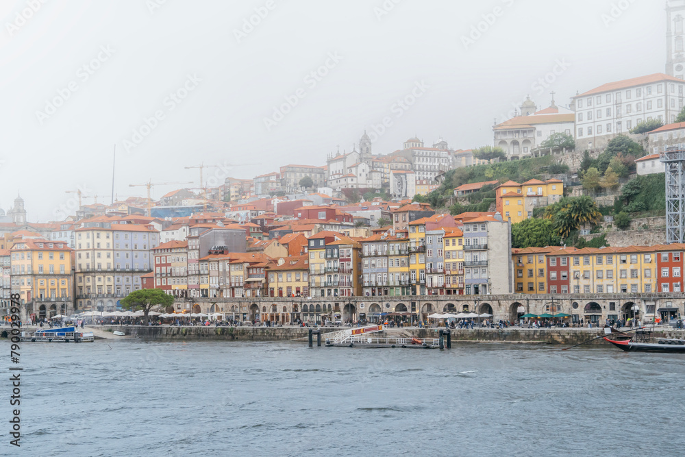 Porto, Portugal Skyline, the old town of Porto from across the Douro River. Colorful houses of Porto Ribeira, traditional facades, old multicolored houses with red tiles during a foggy day, Portugal.