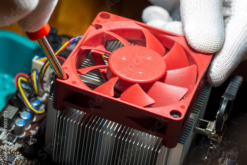 A technician installing fan cooled heatsink onto the computer processor