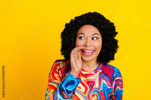 Photo portrait of attractive young woman look empty space share secret dressed stylish colorful clothes isolated on yellow color background © deagreez