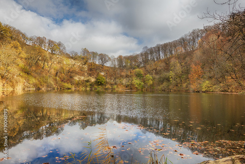 autumn day on a mountain lake of karst origin surrounded by a yellowing forest