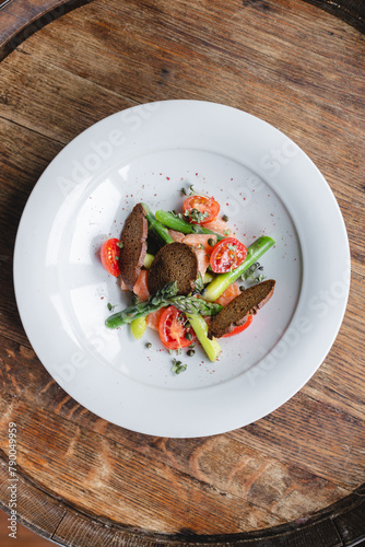 Salad with croutons, salmon, asparagus and tomatoes. Spring menu, restaurant, lunch, brunch, diet.