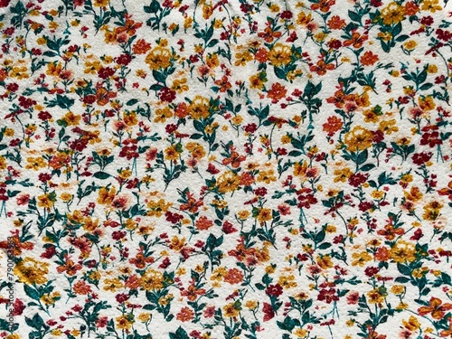 Fabric with a delicate floral pattern, close-up as texture. Old-fashioned cotton or linen textile in a retro style with a print of scattered colorful flowers. Bright floral background. 
