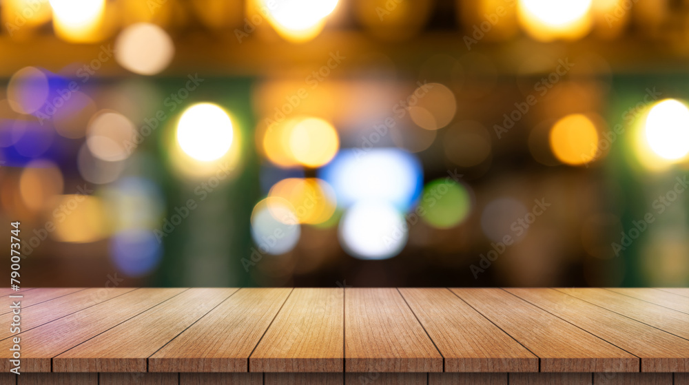 Empty wooden table top with lights bokeh on blur restaurant background.