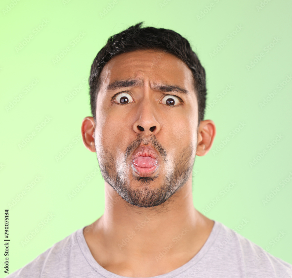 Man, portrait and humor in studio, tongue and goofy comic or funny face on green background. Male person, mockup space and guy for joke or comedy, student and awkward for crazy character and quirky Man, portrait and humor in studio, tongue and goofy comic or funny face on green background. Male person, mockup space and guy for joke or comedy, student and awkward for crazy character and quirky