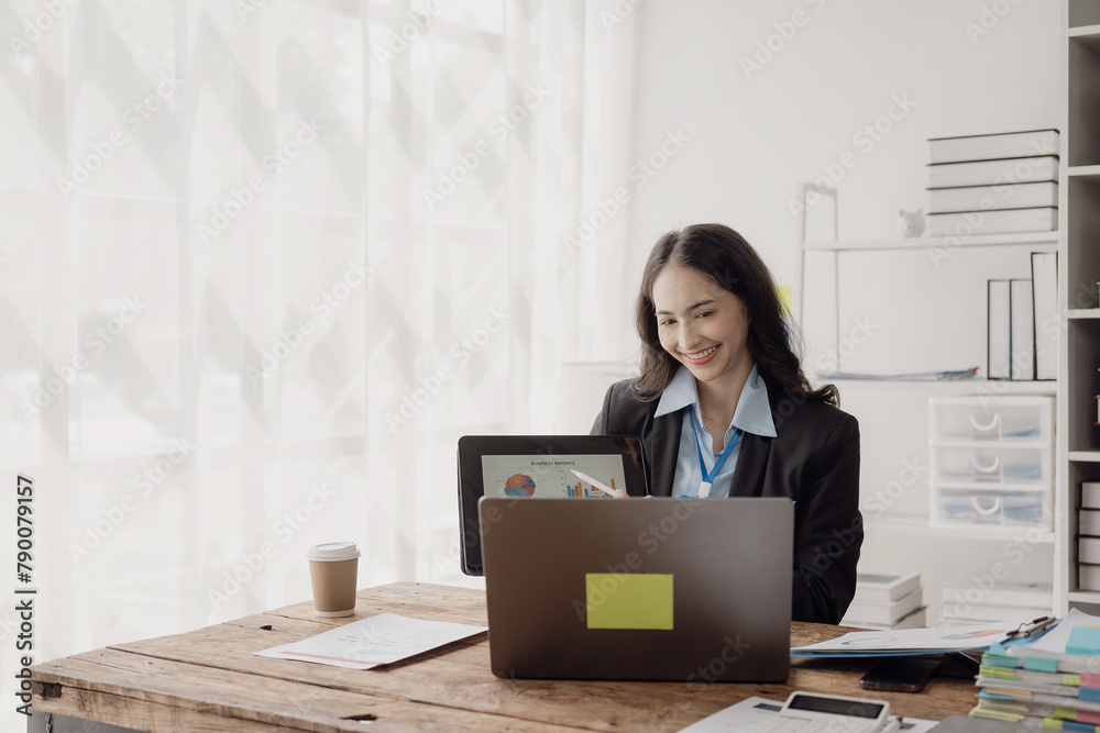 Asian businesswoman working in office with documents and laptop The worker documents, calculates financial indicators, smiles and is happy about the success of the business. Asian businesswoman working in office with documents and laptop The worker documents, calculates financial indicators, smiles and is happy about the success of the business.