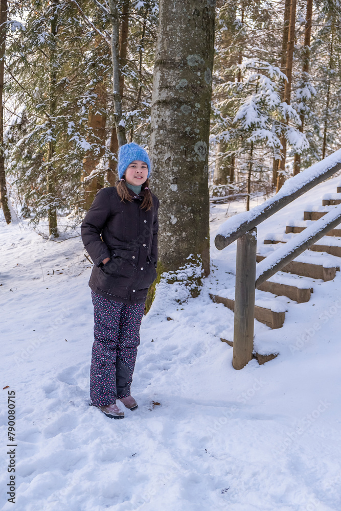 portrait of a 10-year-old girl in a winter forest in winter clothes on the playground portrait of a 10-year-old girl in a winter forest in winter clothes on the playground