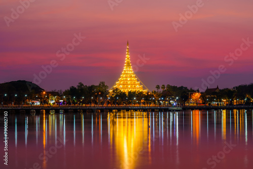 View of the pagoda Wat Nong Waeng, beautifully lit up at dusk, from a distance.