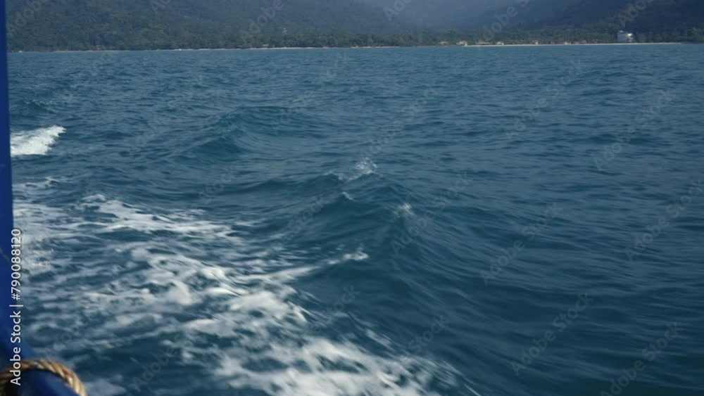 Yacht sailing in calm blue waters under a sunny sky with waves and distant horizon Yacht sailing in calm blue waters under a sunny sky with waves and distant horizon