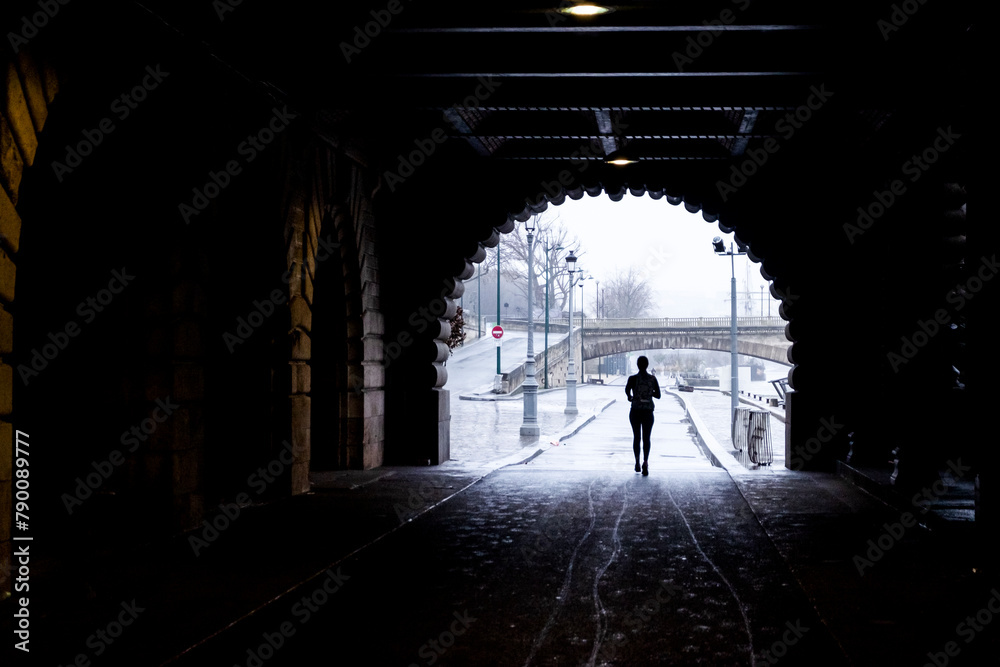 Athlete Runner under a bridge in the city of Paris beside the Seine river