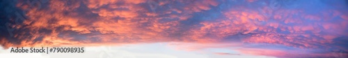 colorful wide sunset sky panorama with mammatus clouds, orange and purple colored