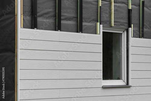 wood texture composite cladding installation on house facade. WPC exterior wall siding panels