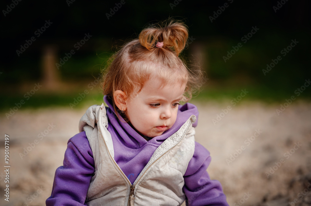 Engrossed in play, a young toddler fills a cup with sand, surrounded by colorful toys in a sandbox, a picture of focus and discovery Engrossed in play, a young toddler fills a cup with sand, surrounded by colorful toys in a sandbox, a picture of focus and discovery
